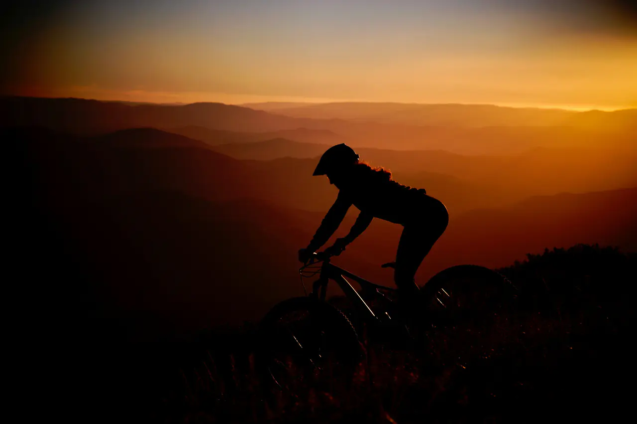 A mountain biker silhouetted at sunset